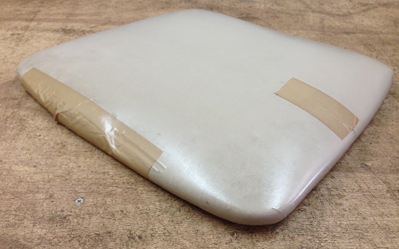 破れをテープで補修した座面